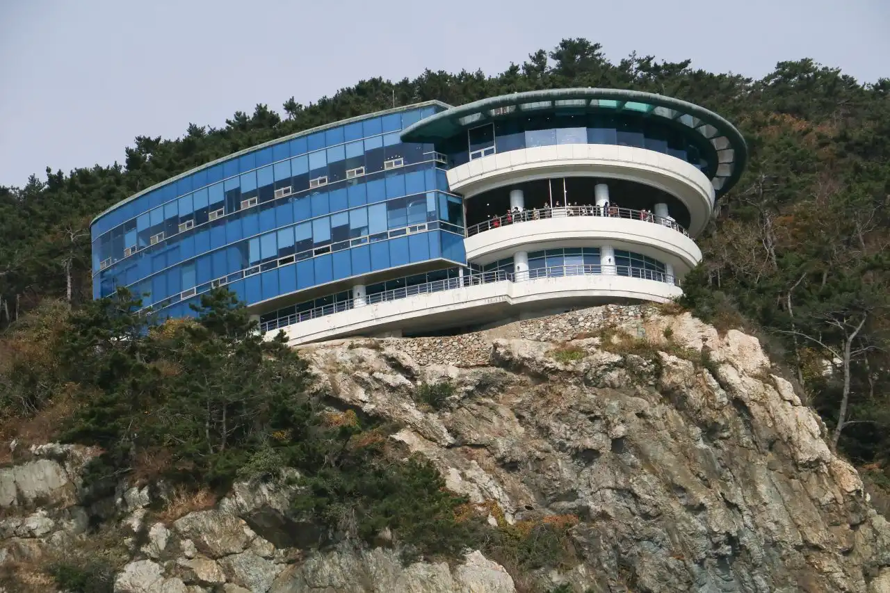 The round glass Taejongdae Observatory perched on top of a sheer rock cliff