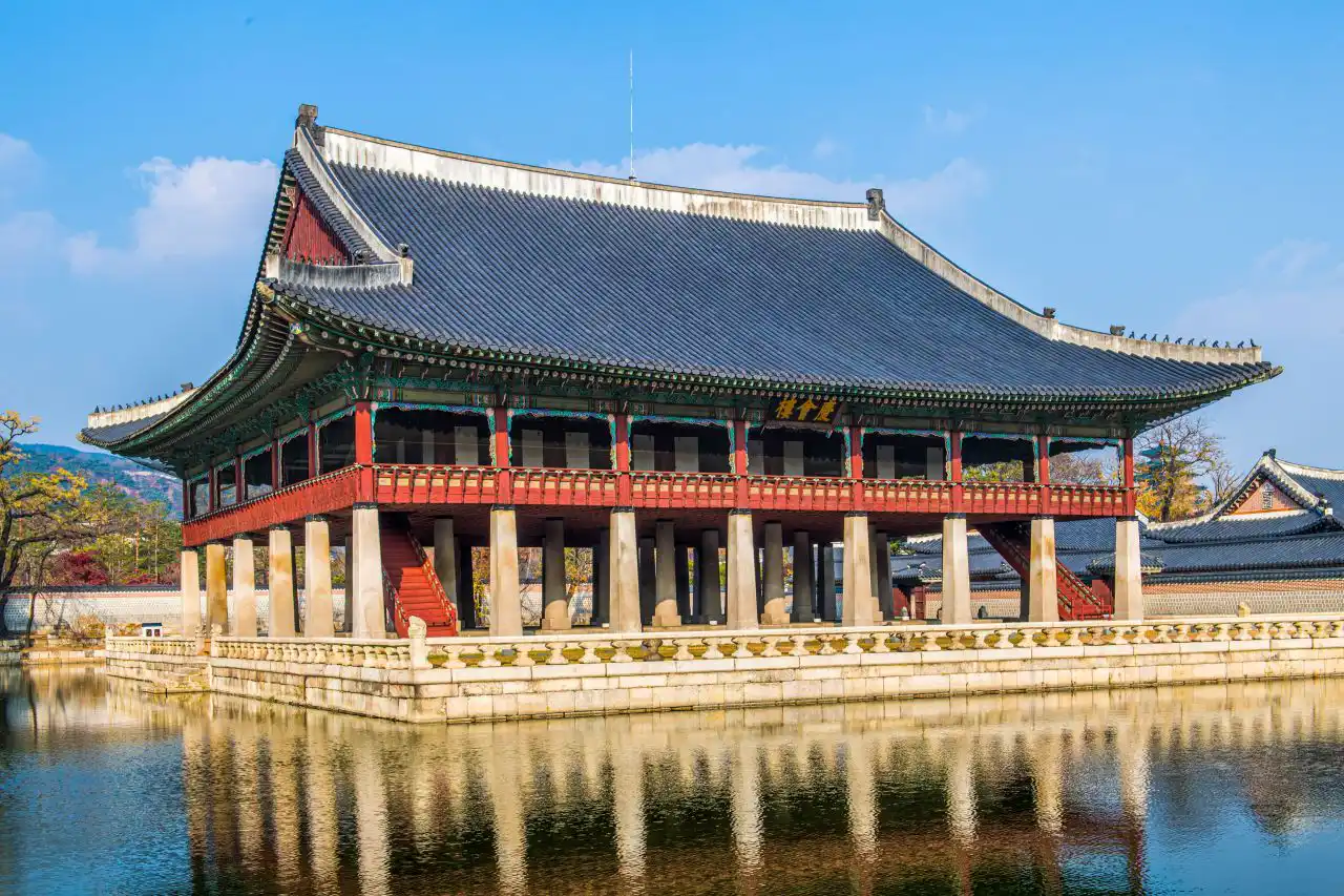 Gyeonghoeru pavilion over its pond under a clear sky, mirrored in the water