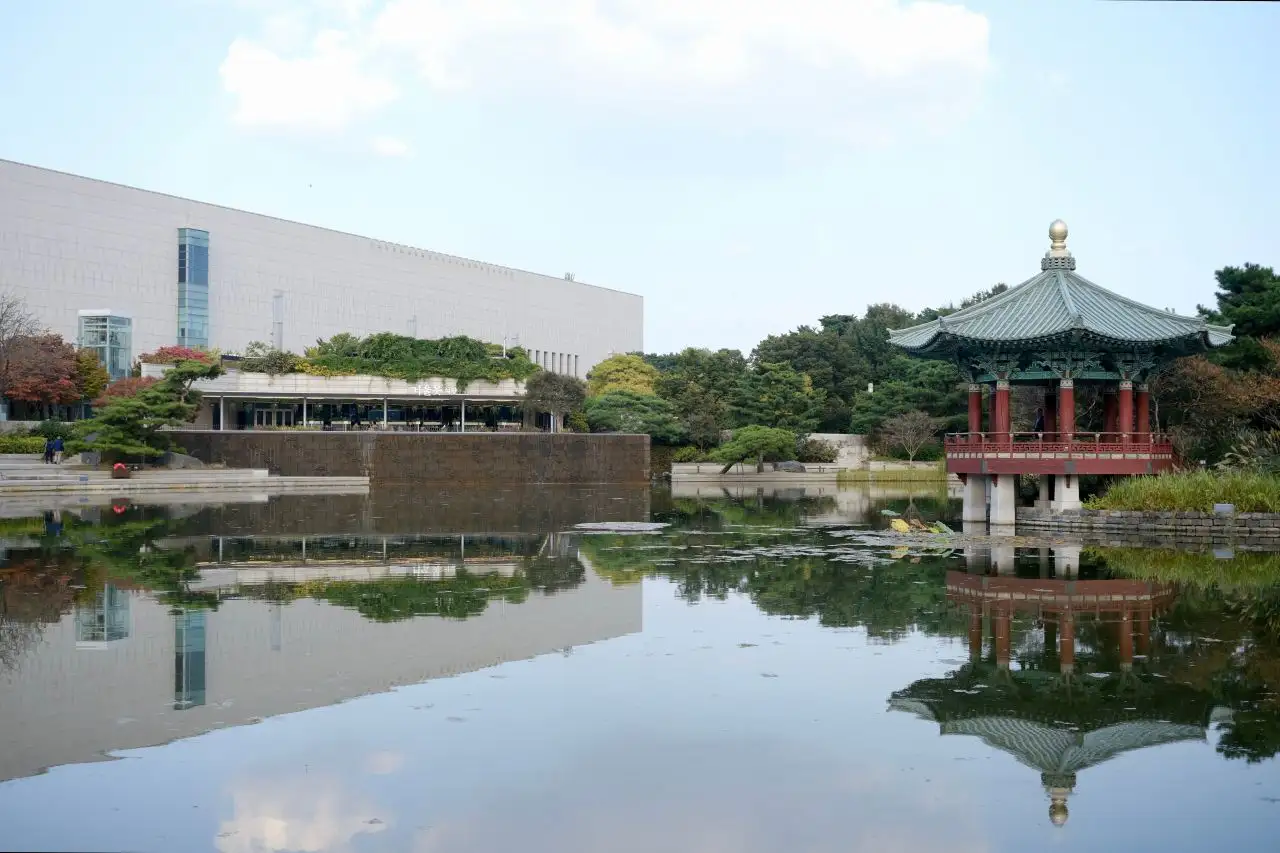 The museum building and pavilion mirrored in the still Geoulmot pond