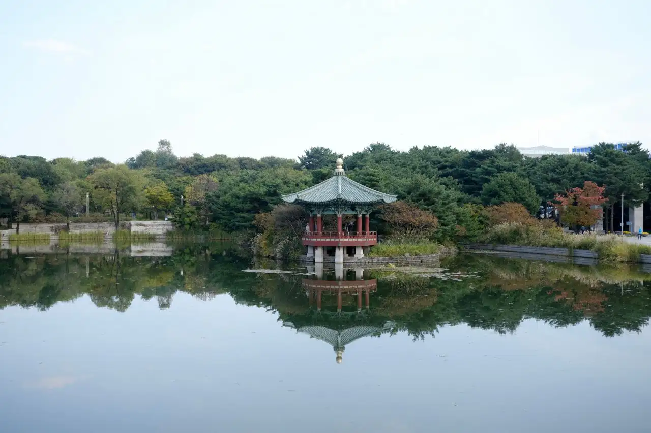 The pond garden in autumn, its pavilion reflected among the turning trees